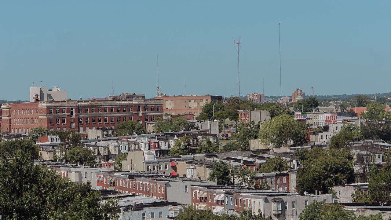 U.S. residential city skyline for affordability research Residential rooftops and city skyline used to illustrate research into budget friendly U.S. cities
