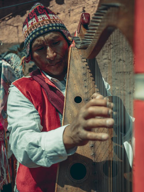 Man in Traditional Clothing Playing Harp