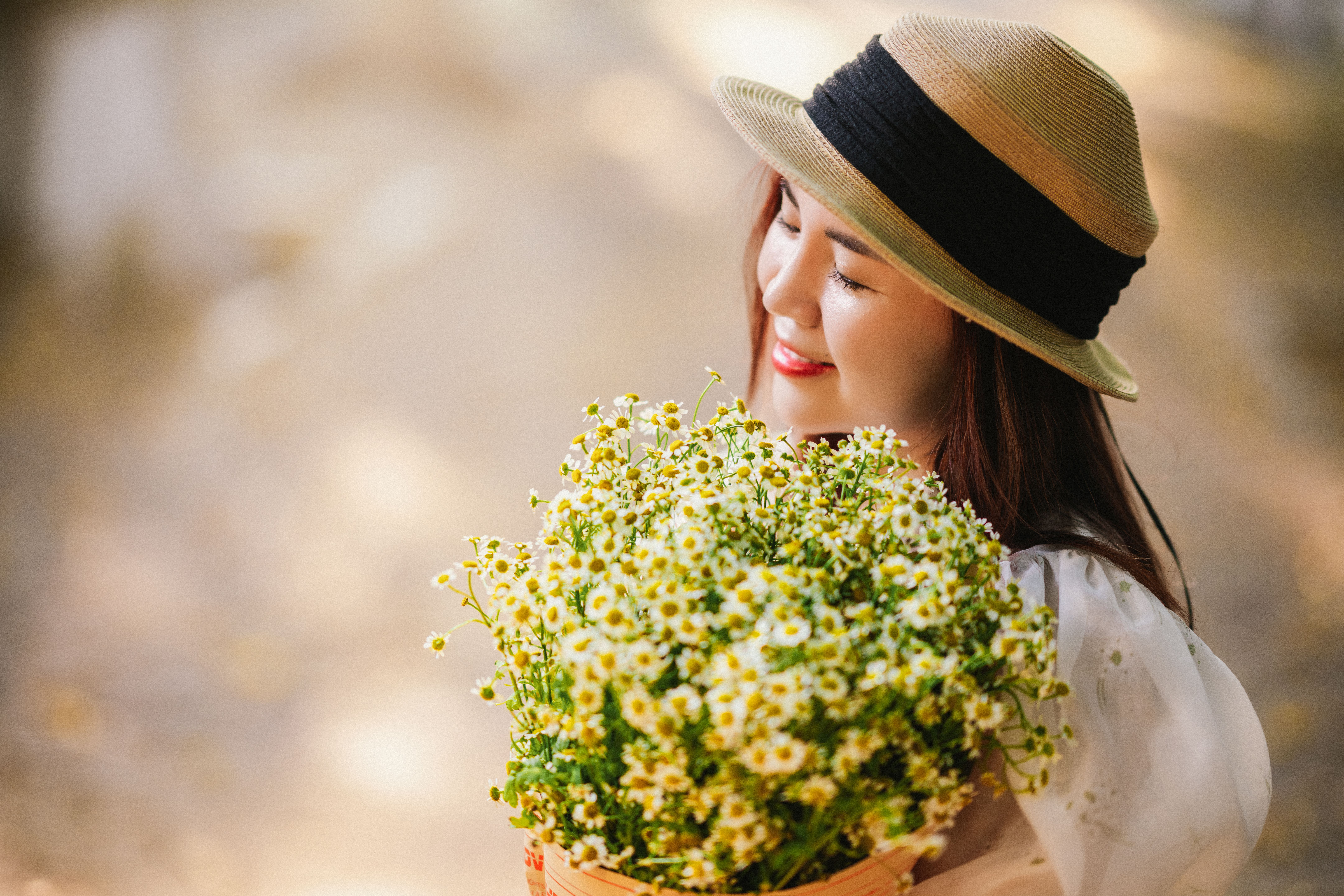 Woman Wearing Hat Holding a Bouquet of Flowers · Free Stock Photo