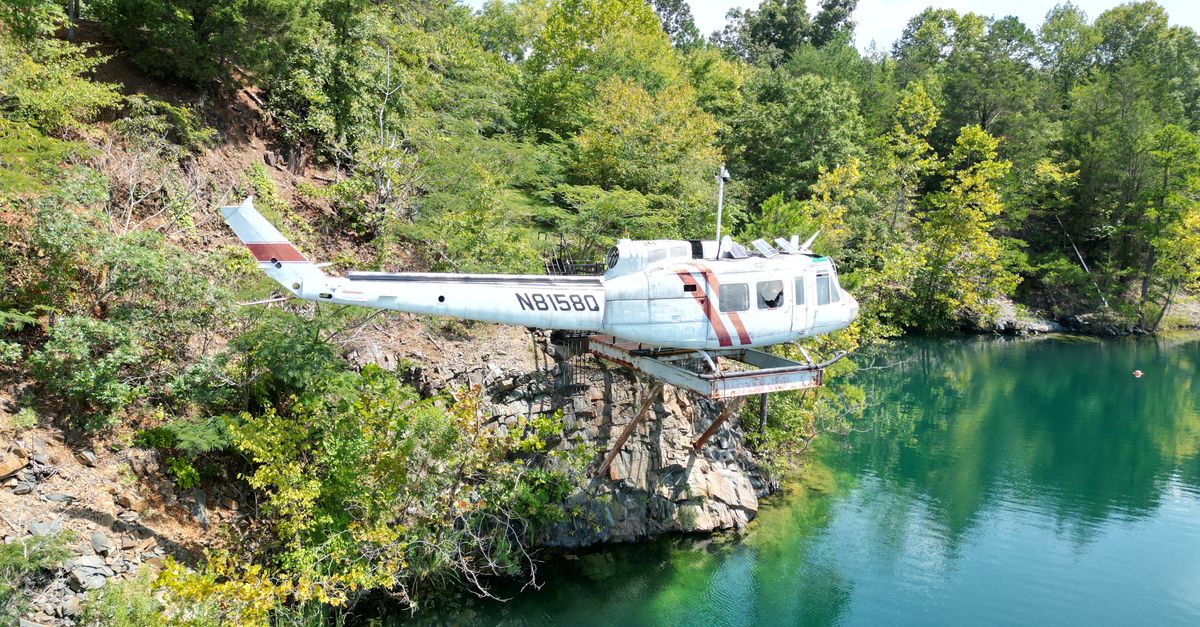An abandoned helicopter on a cliff surrounded by trees and a lake in Thomasville, NC.