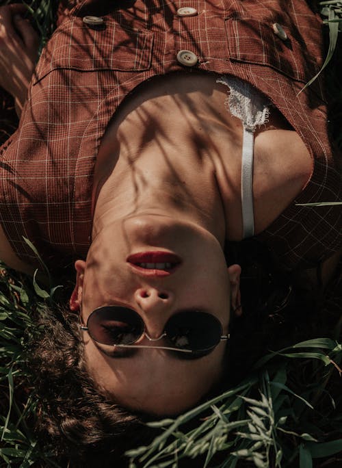 Wanita Mengenakan Kacamata Hitam Berbaring Di Tanah