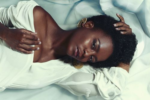 Free A stylish black woman posing gracefully on a white background in fashion photography. Stock Photo