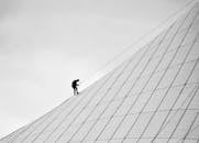 Man Climbing on a Modern Building in Black and White