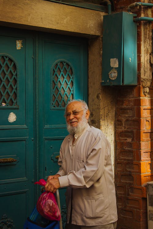Eldery Man Standing in front of an Entrance Door 