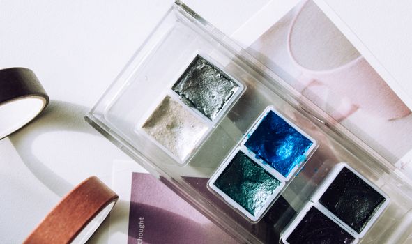 A creative flat lay of vibrant watercolor paints showcasing artistic tools with vivid colors.