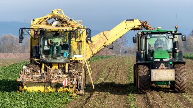 Tractor and harvester working in a field near Hamburg during harvest season.