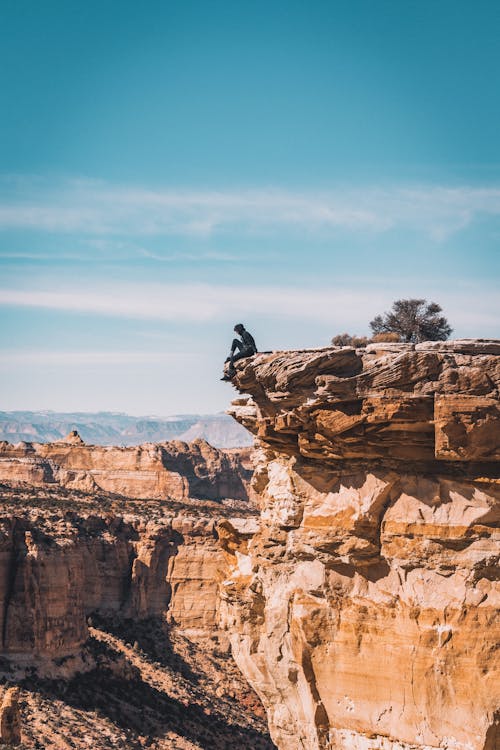 Free Man Sitting At The Cliff Stock Photo