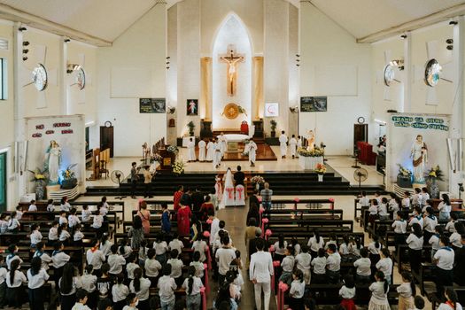 A vibrant wedding ceremony in a church in Ho Chi Minh City, Vietnam, featuring traditional attire and religious rituals.