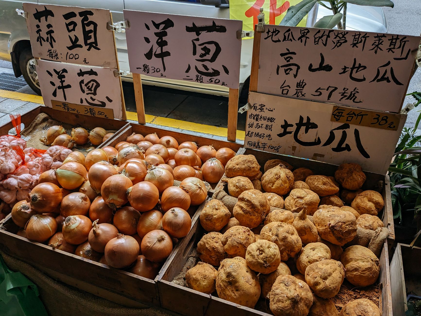 南投文創基地與小農市集景點推薦:在地美食、親子旅遊與交通攻略 Onions and root vegetables artfully arranged in wooden crates at a Taiwanese market stall