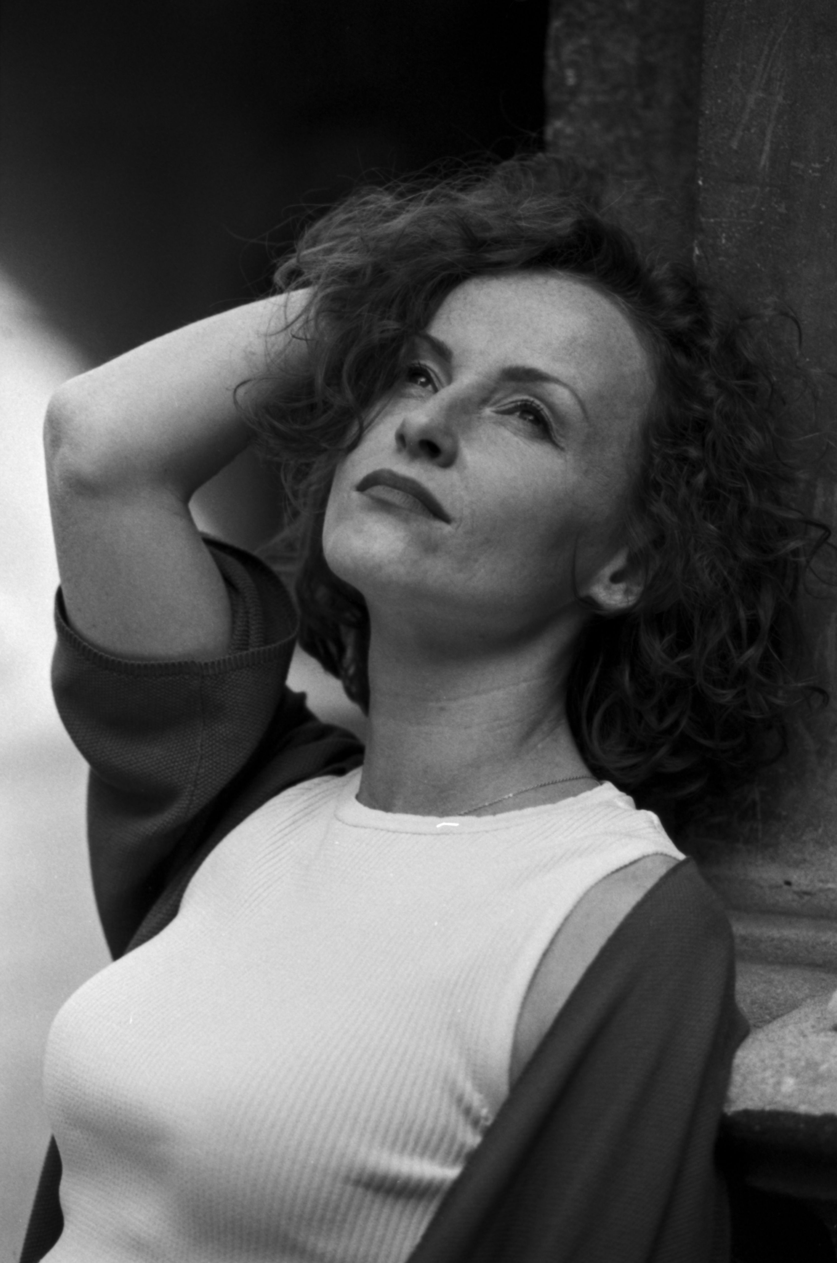 Elegant black and white portrait of a woman with curly hair, posing with confidence.