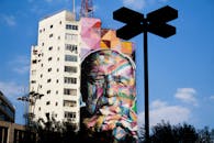 一座高楼被色彩缤纷的街头艺术壁画覆盖，营造出醒目的城市视觉