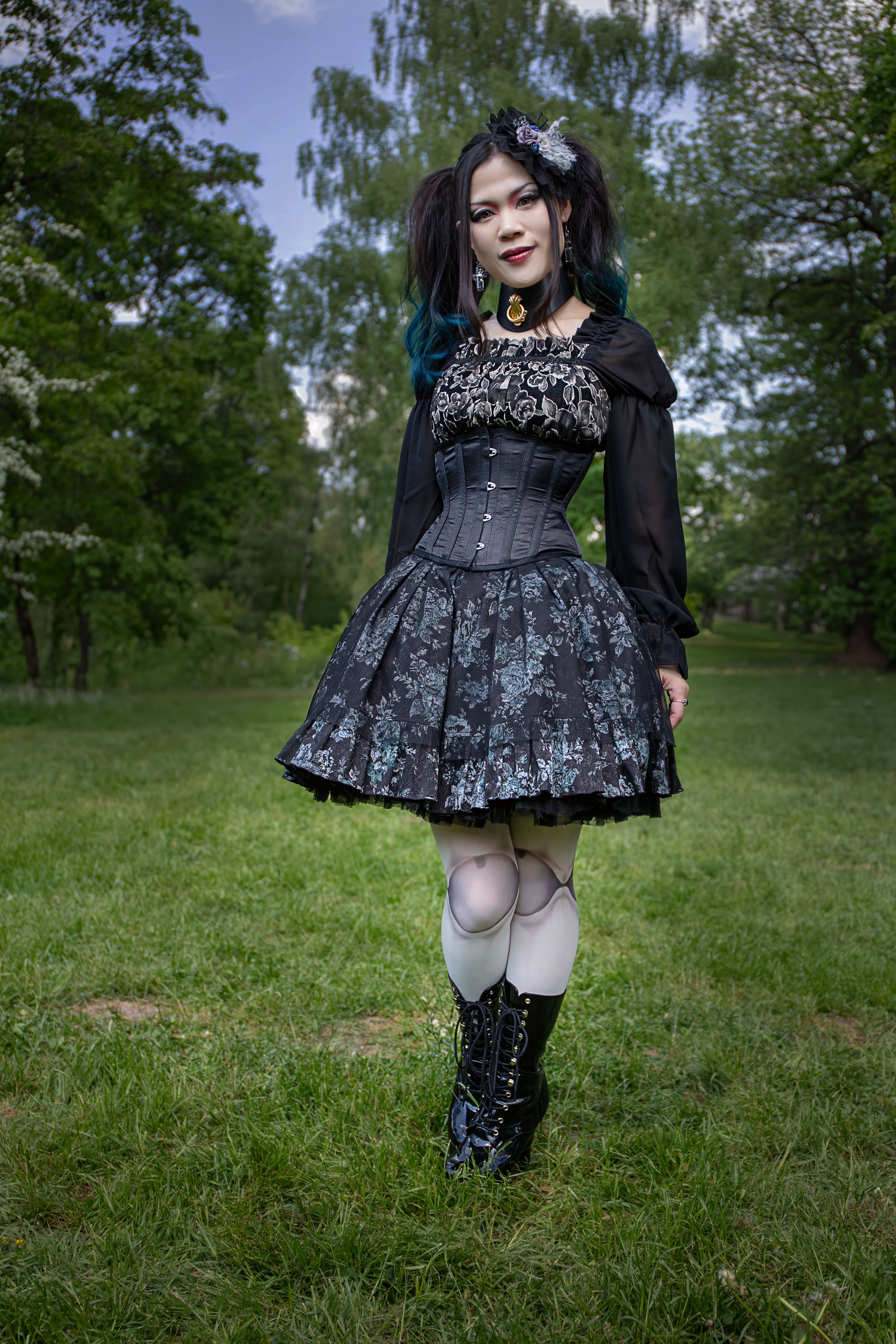 A woman in a gothic dress posing in the grass · Free Stock Photo