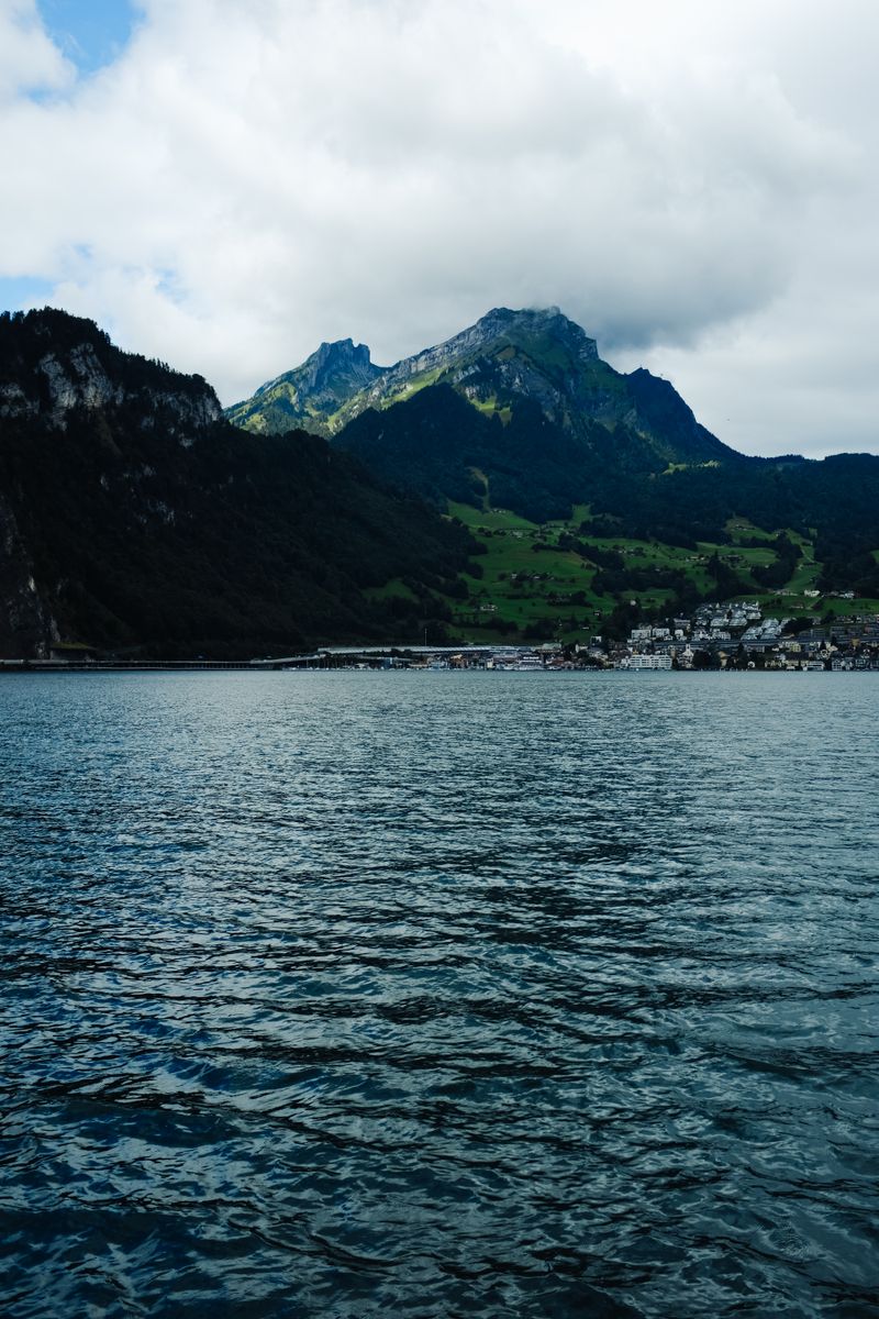 Mountain village on a lake under low cloud — photo by Adrien Olichon on Pexels