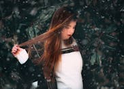 一位长发年轻女子的肖像，在白雪皑皑的户外环境中，展现出优雅与风格