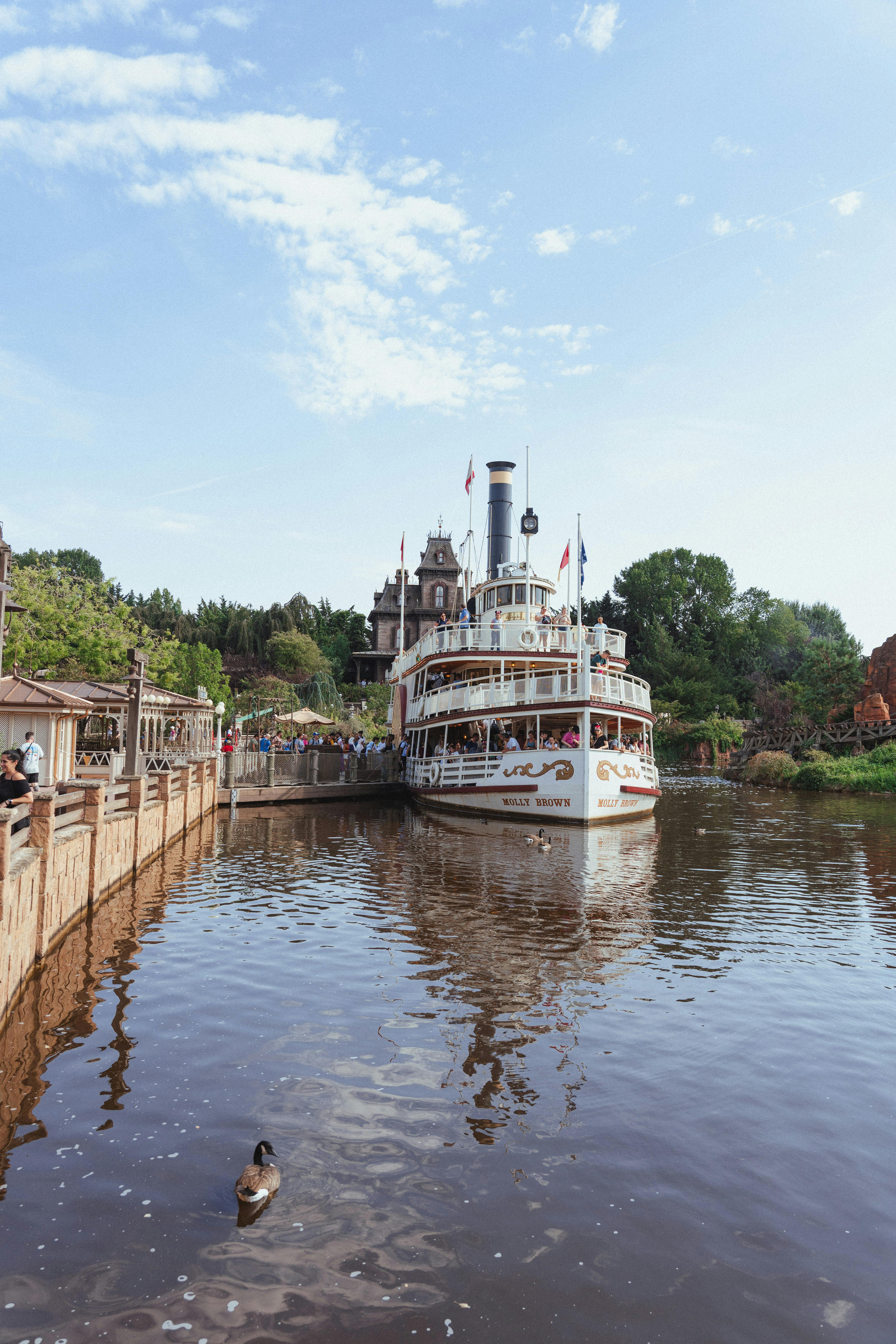 Riverboat cruising through Disneyland Paris with passengers enjoying the iconic scenery.