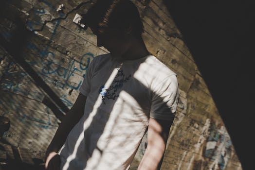 涂鸦墙的艺术阴影中站着一个人，营造出一种神秘的氛围