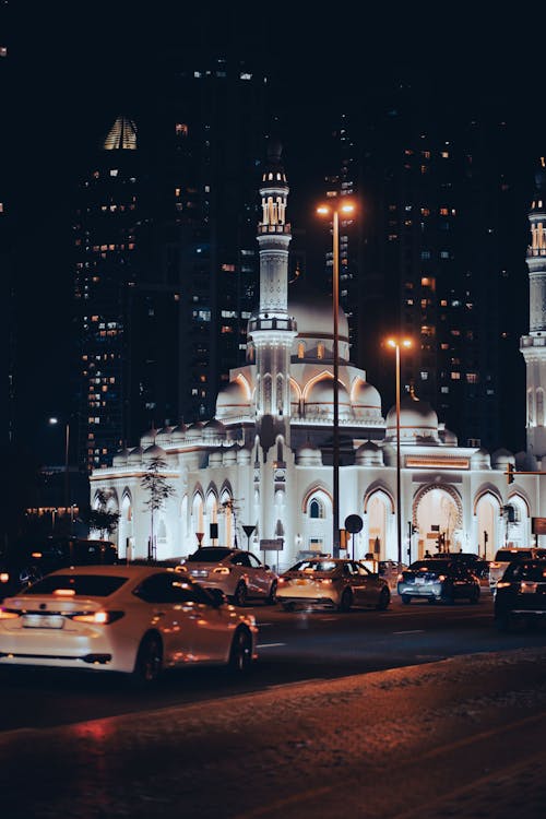 Cars near Illuminated Mosque at Night