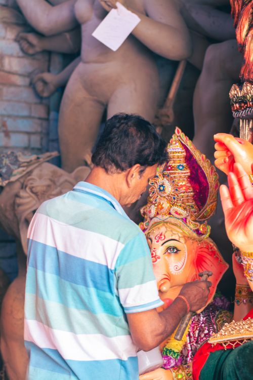 Free An artist carefully crafts a Ganesha idol in a Kolkata studio, showcasing traditional artistry. Stock Photo