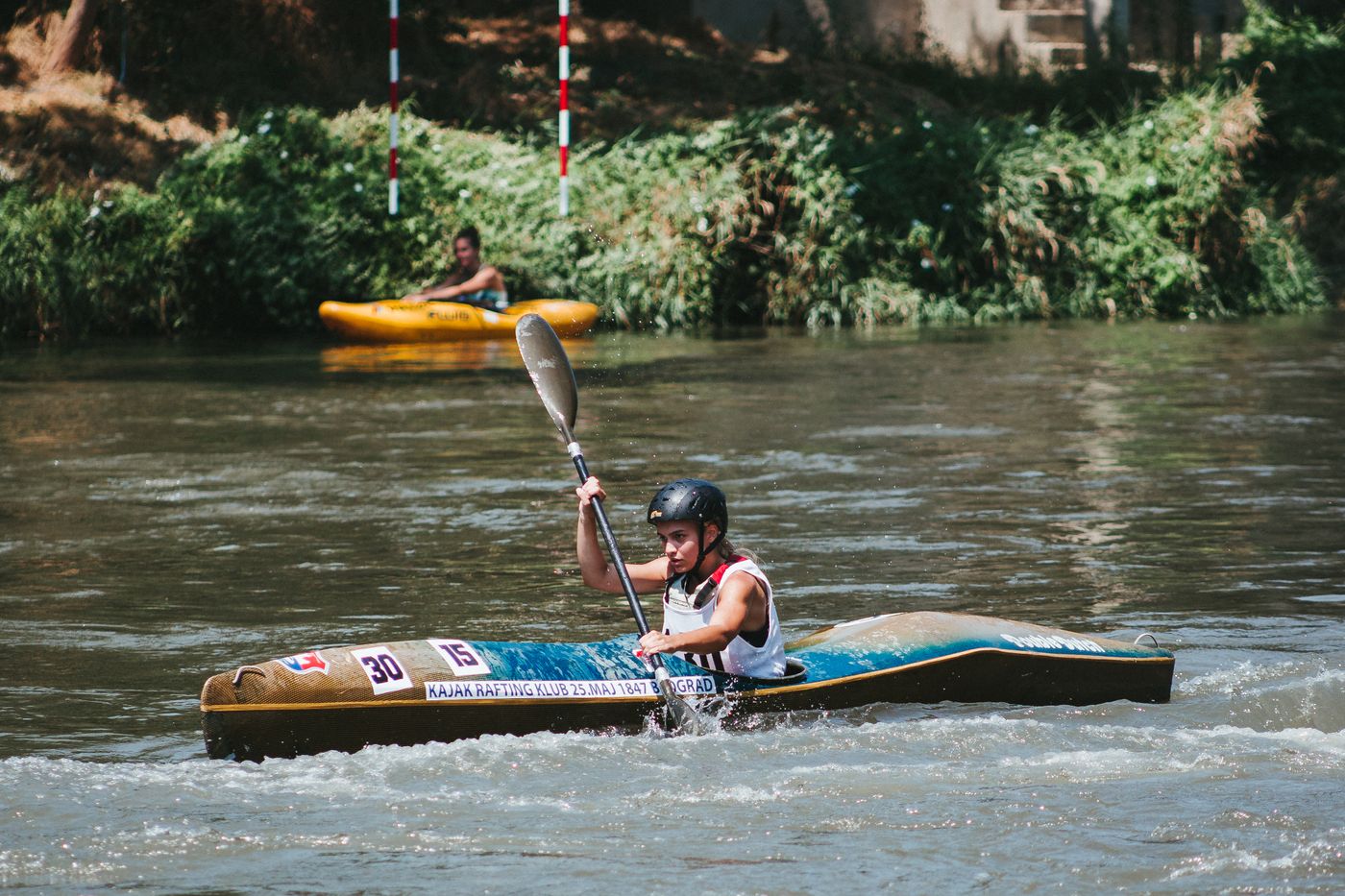 Kayaker wearing safety gear while paddling on a river