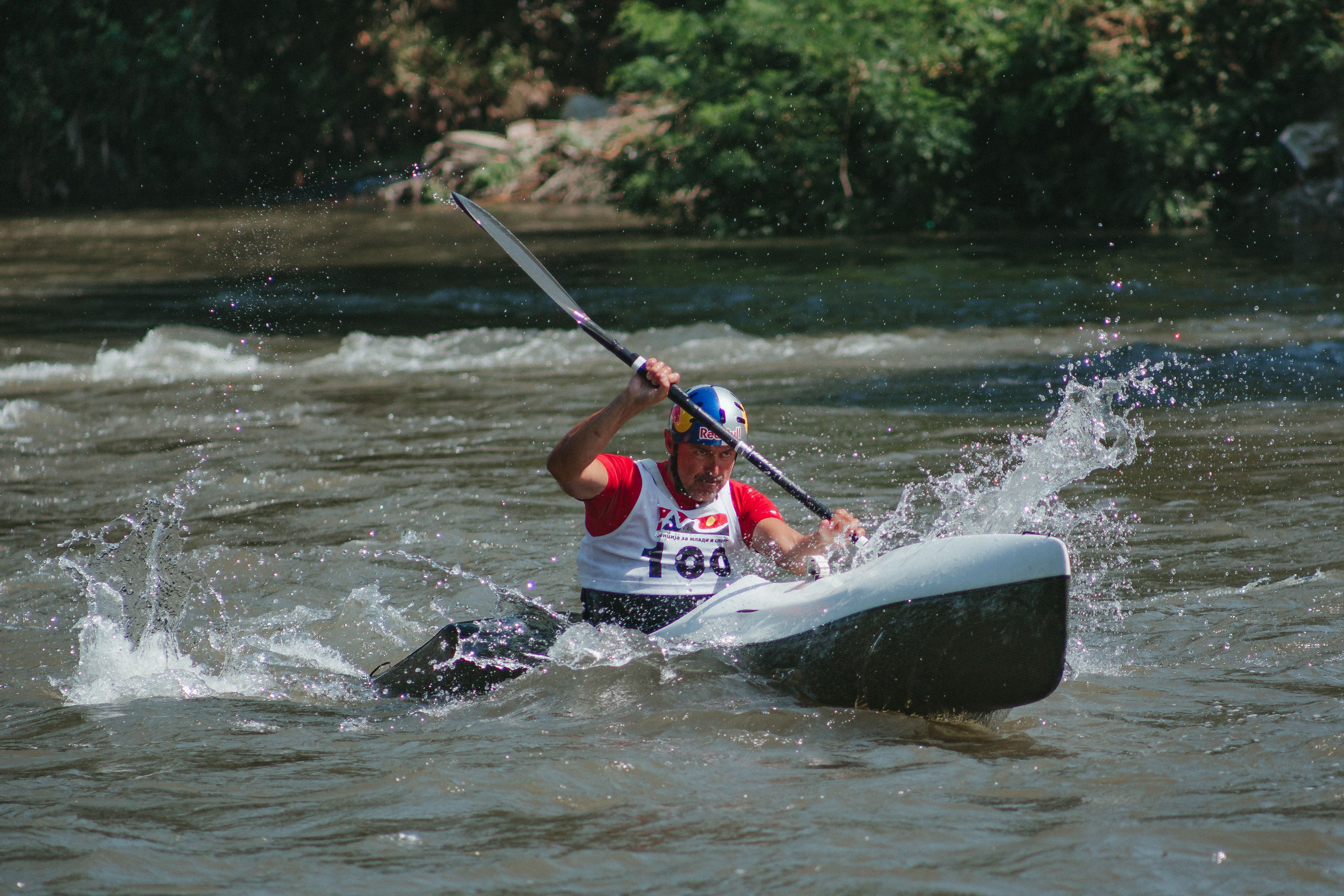 Intense moment of a canoe race with a sportsman navigating rapids on a sunny day.