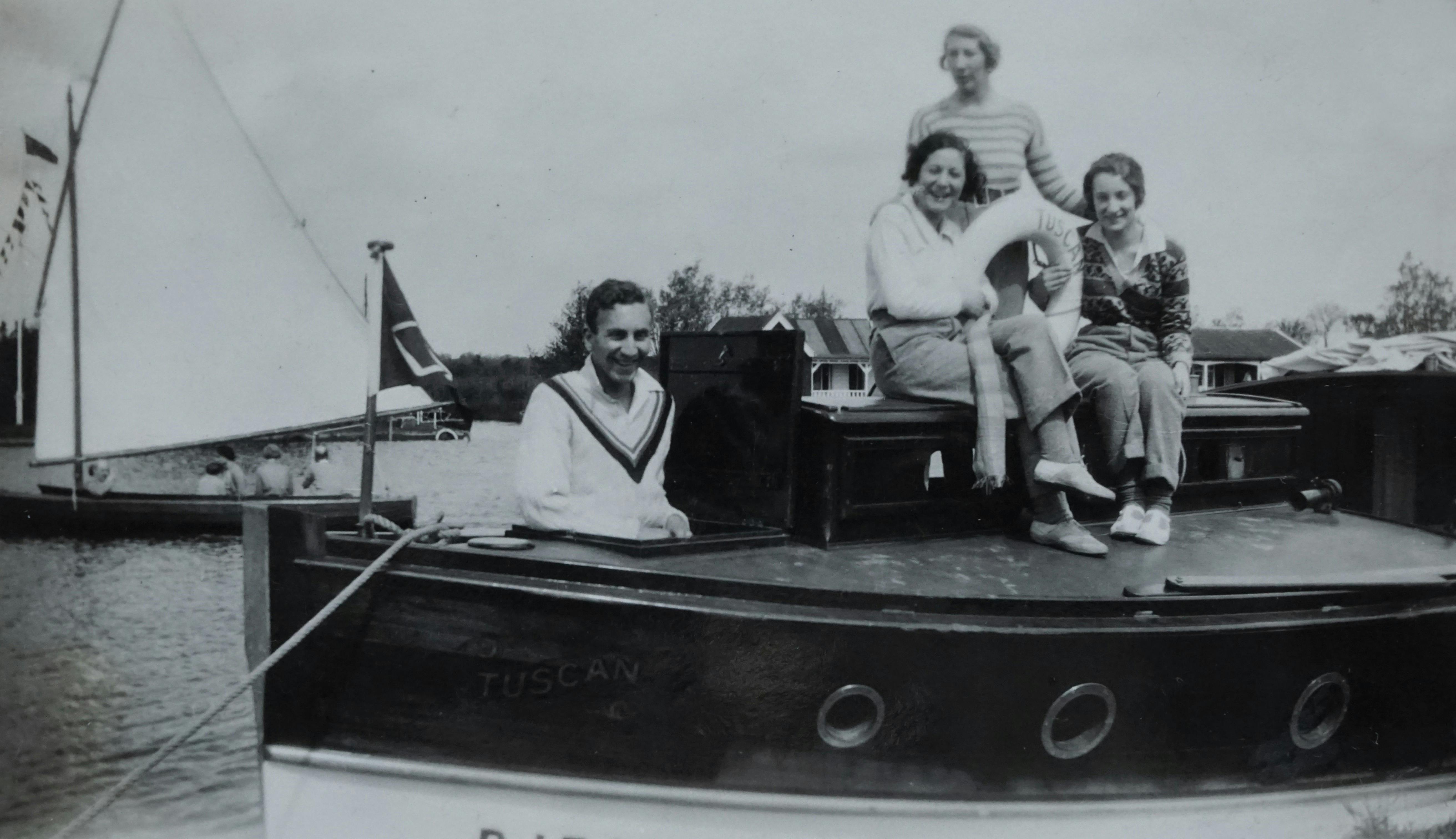 Black and white photo of people enjoying leisure time on a boat.