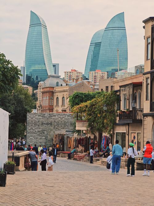 Free Baku's modern Flame Towers overlooking the historic old town, merging contemporary and historical architecture. Stock Photo
