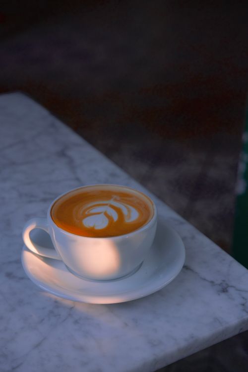 Free Artistic cappuccino served on a marble table, emphasizing the latte art in a serene indoor setting. Stock Photo