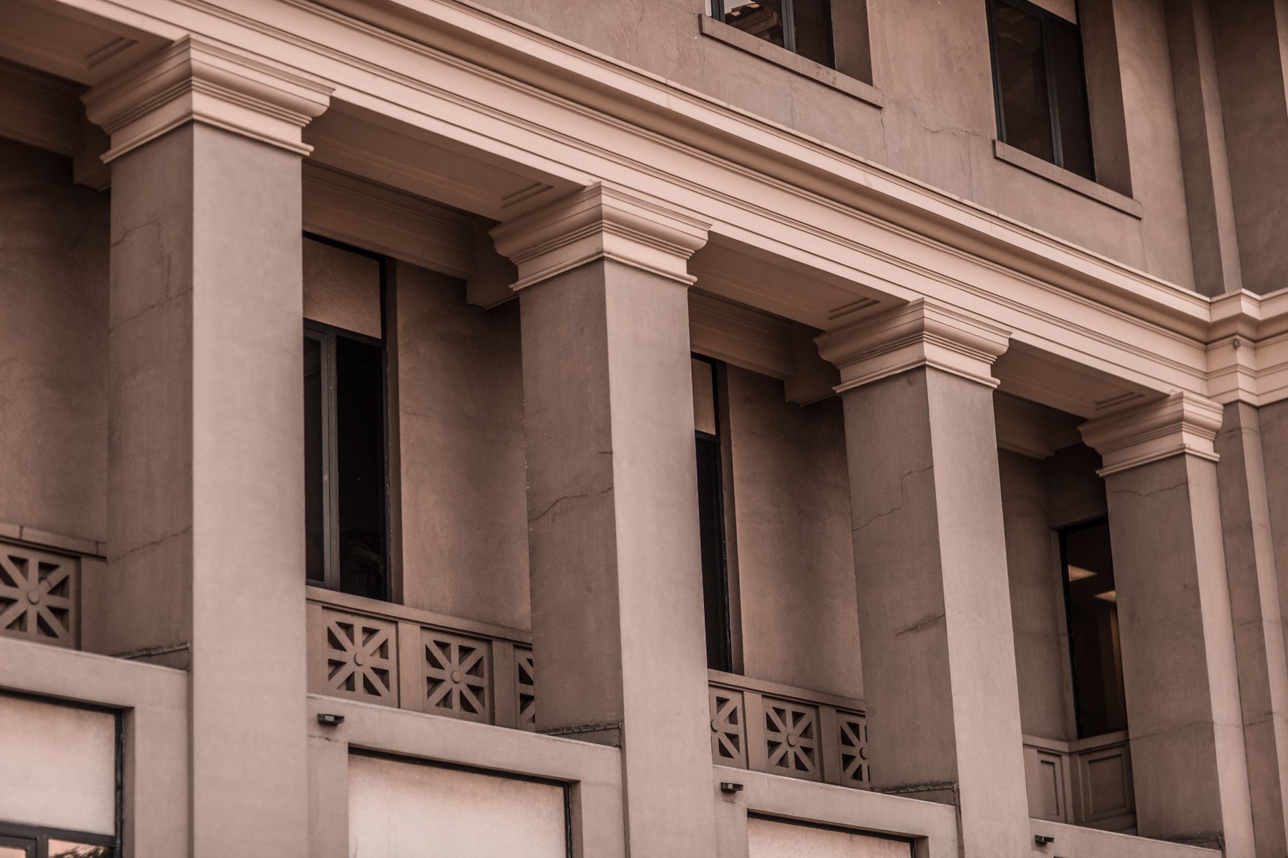 A detailed view of a classic building facade featuring pillars and windows.