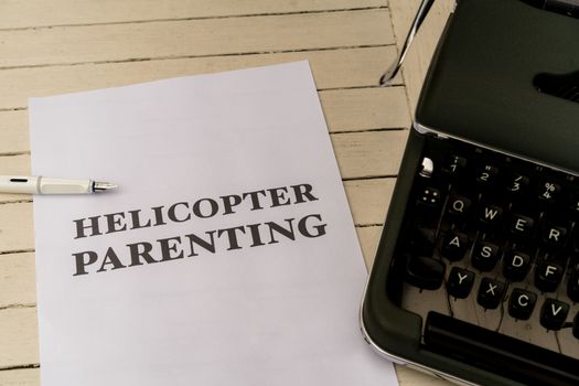 A typewriter with the words helicopter parenting on it