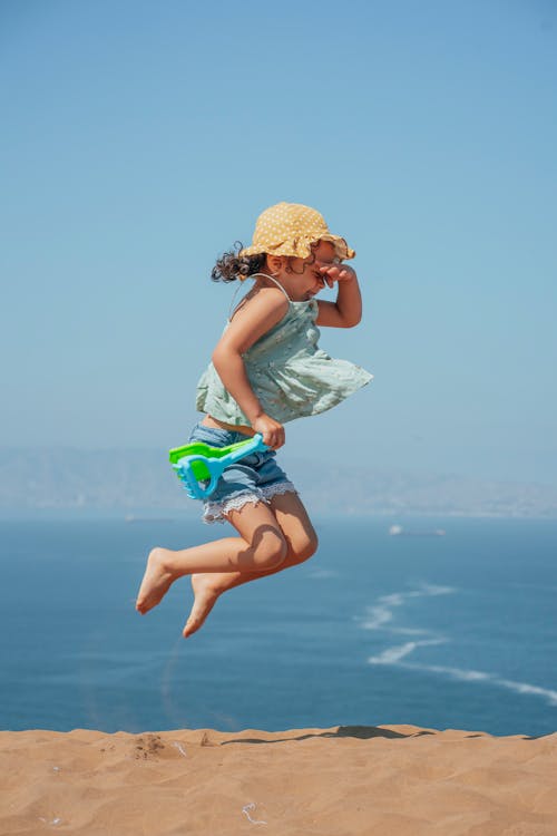 Girl Jumping on Sand Shore