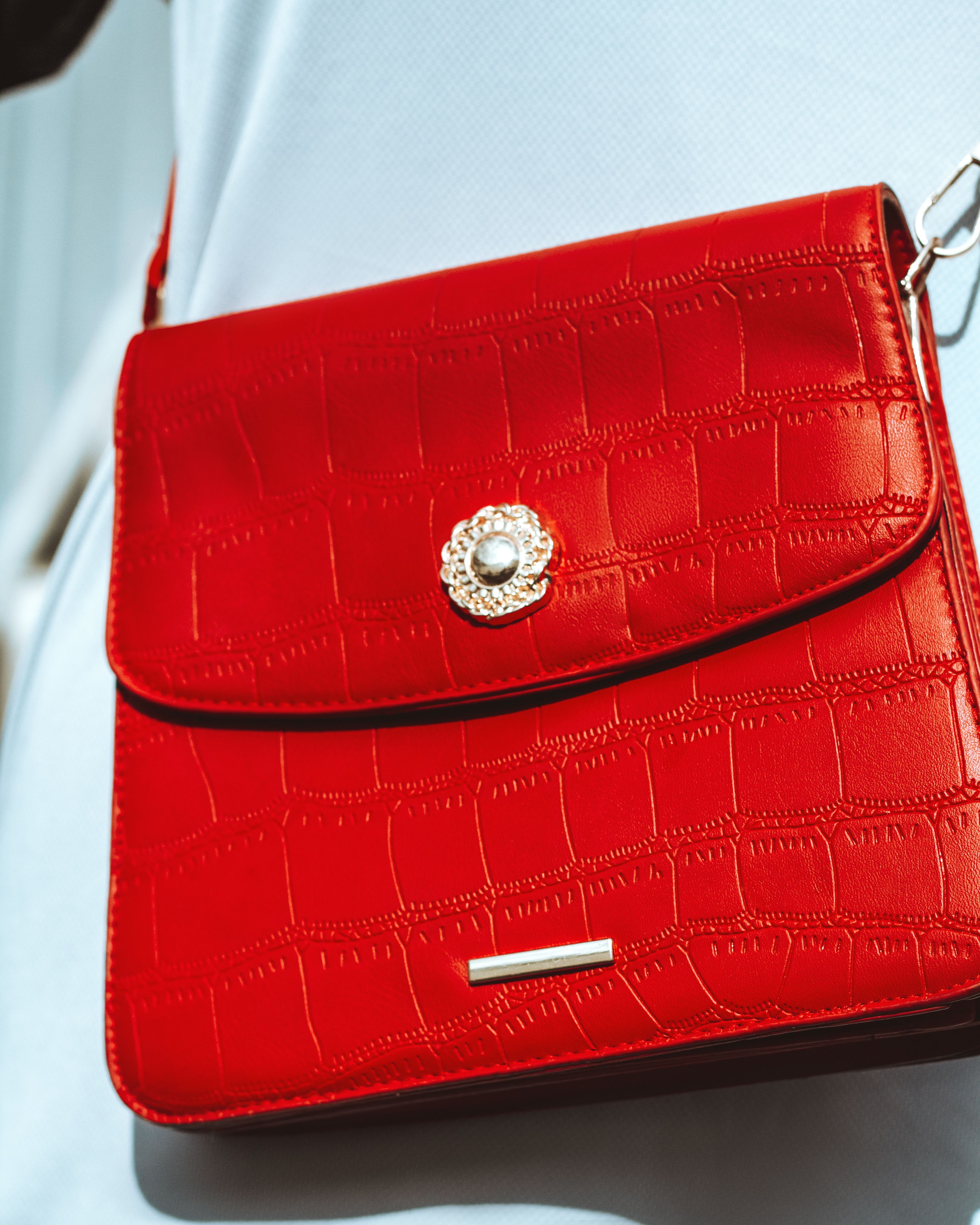 Close-up de uma bolsa vermelha estilosa com padrão de crocodilo, perfeita para entusiastas da moda.