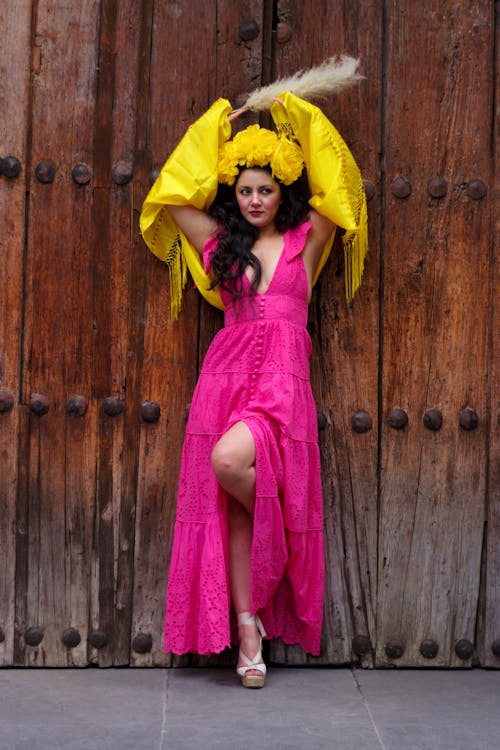 Woman Posing in Pink Dress and with Arms Raised