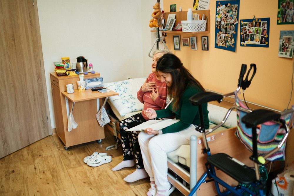 A Thistledown caregiver sharing a warm moment with a senior woman in her living room