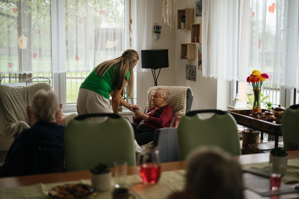 Caregiver serving tea to elderly women