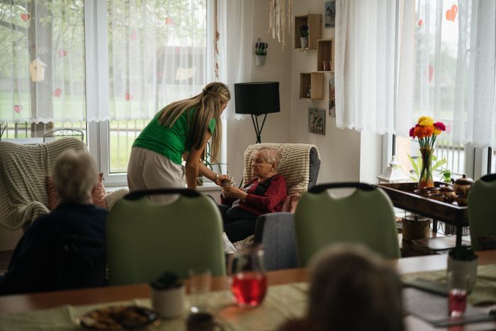 Caregiver helping an elderly resident in a nursing home