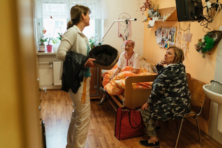 Caregiver Talking With Elderly Women In Nursing Home