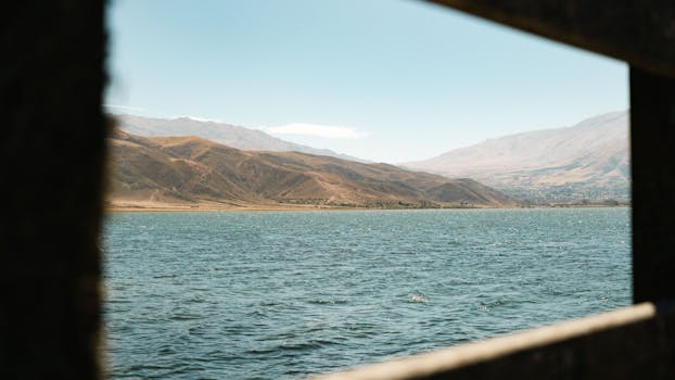 Serene landscape of Tafí del Valle with mountains and lake under clear sky.