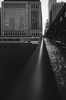 一张引人注目的黑白照片，展现了通往现代城市景观的桥梁