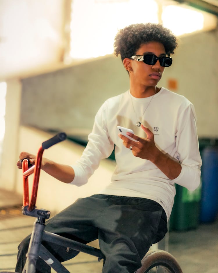 Young Man On Bicycle With Smartphone