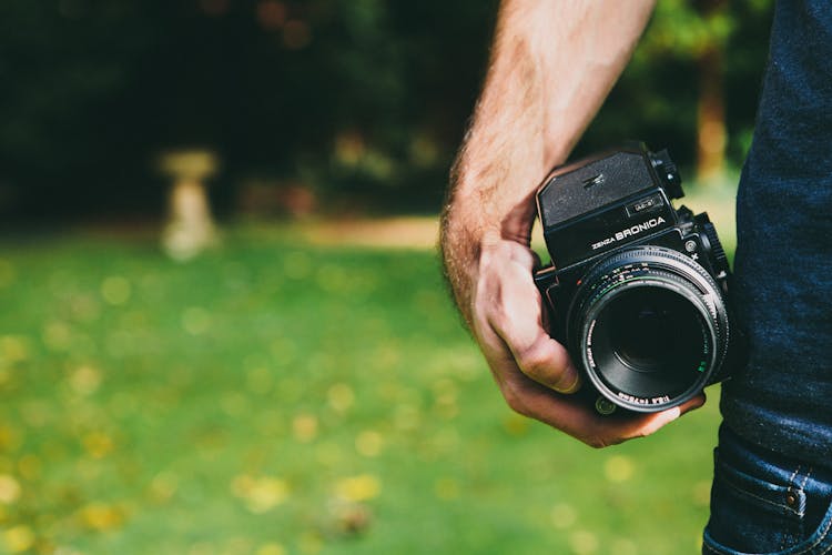 Person Holding Black SLR Camera