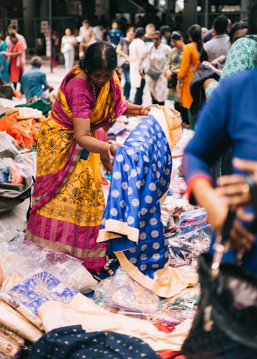 женщина держит сине белое индийское традиционное платье рядом с людьми