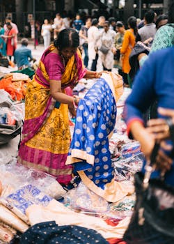 在充满活力的印度市场，人们在户外购买传统的沙丽