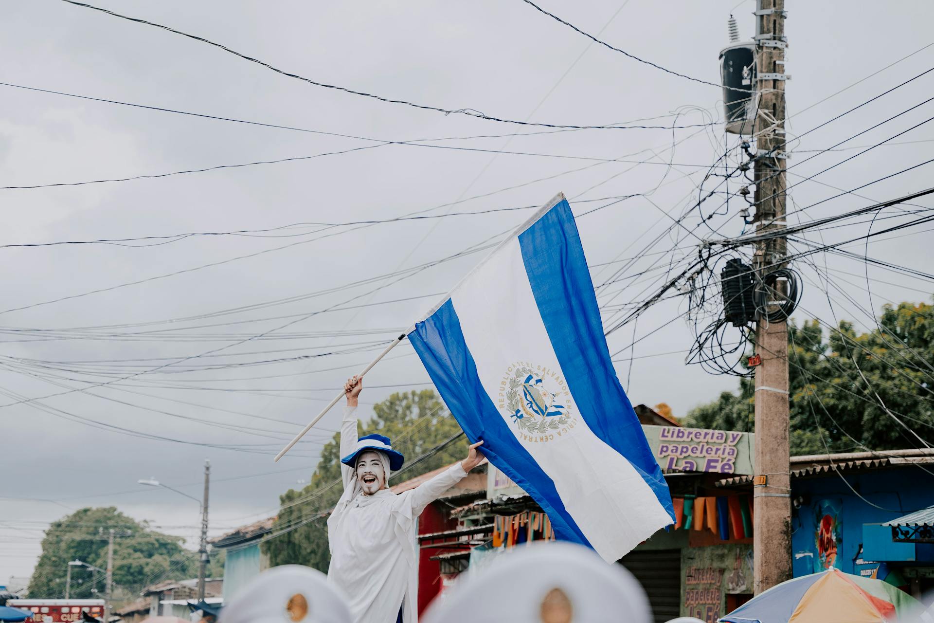 A vibrant celebration in El Salvador featuring a participant proudly waving the national flag.