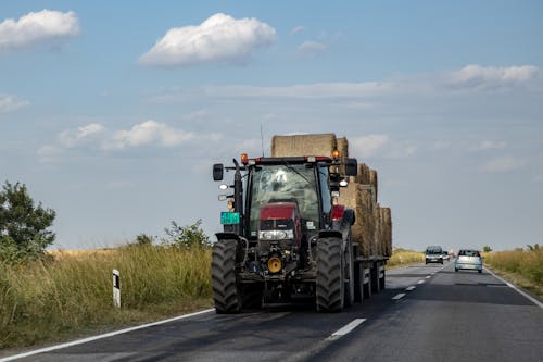 Tractor with Bales of Hay Running on Road