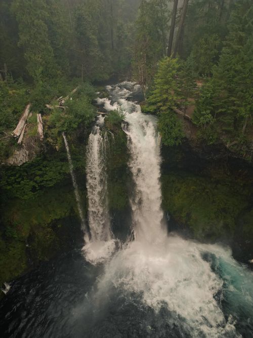 Free A stunning aerial view of a waterfall cascading through lush forests in Oregon, United States. Stock Photo