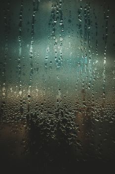 A detailed close-up shot of raindrops creating a textured pattern on a glass window.