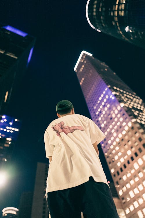 Standing Man Among Illuminated Night Skyscrapers