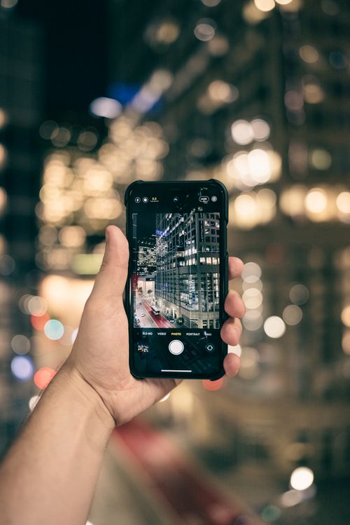 Free Capture of a cityscape through a smartphone at night, depicting modern architecture. Stock Photo
