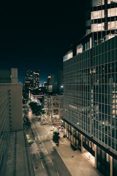 A mesmerizing nighttime view of an urban cityscape with modern architecture and empty streets.