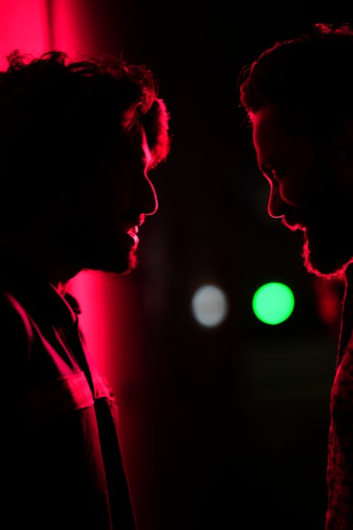 Silhouettes of Two Men Illuminated by Red Light